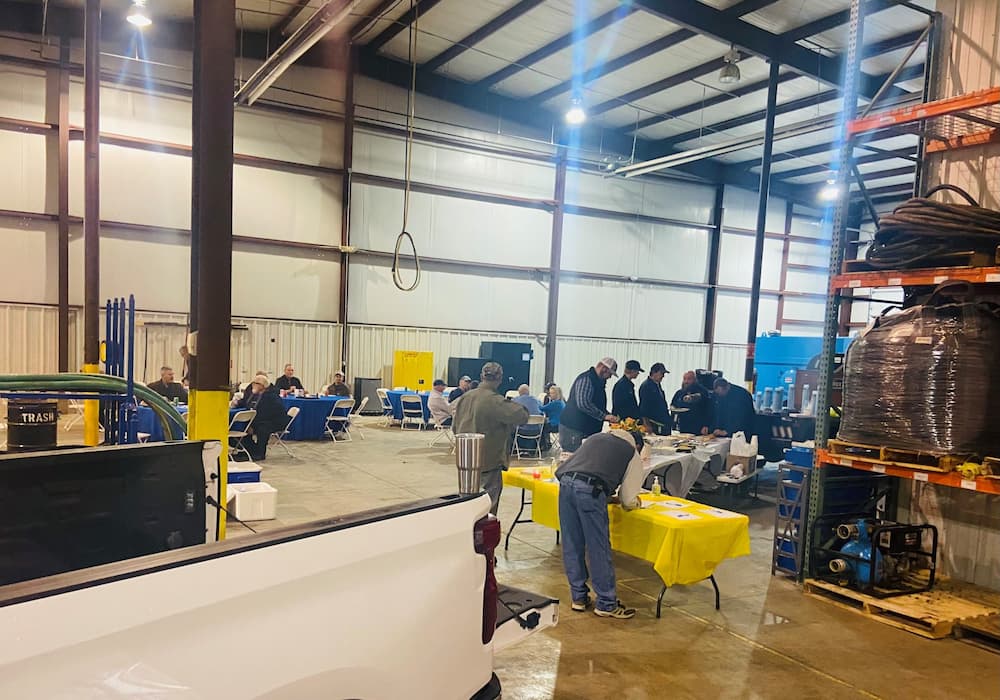 Community members attending an open house event at E-Tank’s facility, learning about environmental equipment rental and pump services