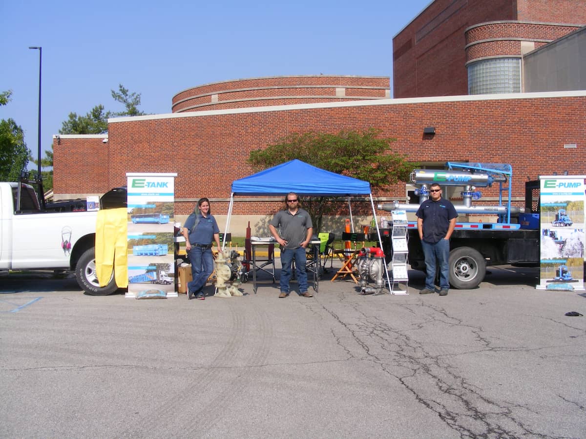 E-Tank and E-Pump team hosting outdoor community event booth with equipment displays and informational banners