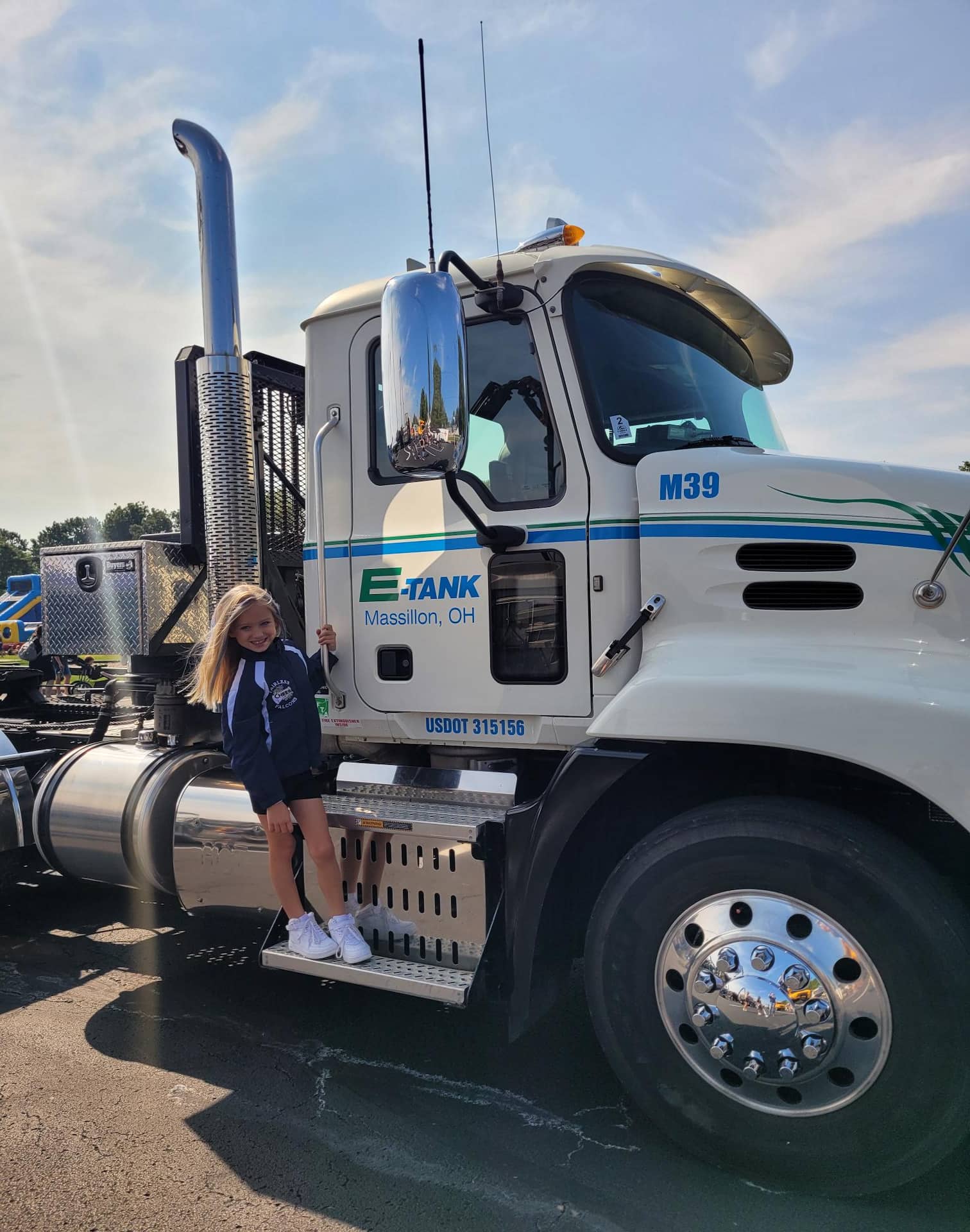 Girl standing on E-Tank Massillon truck during community event, showcasing family-friendly company culture and local engagement