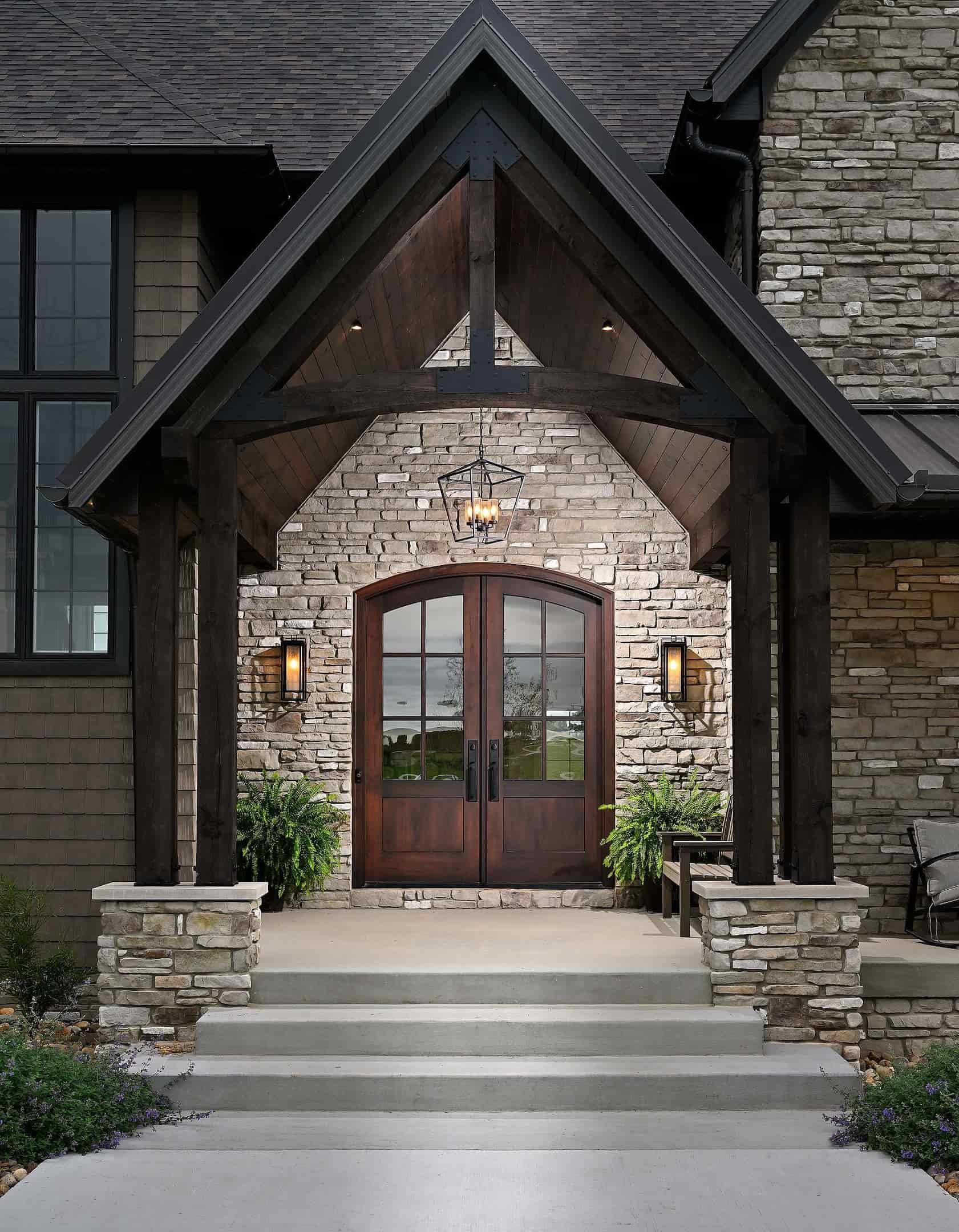 Custom arched double front doors in a modern stone entryway, crafted by Rockwood Door & Millwork for a luxury home in Sugarcreek, Ohio