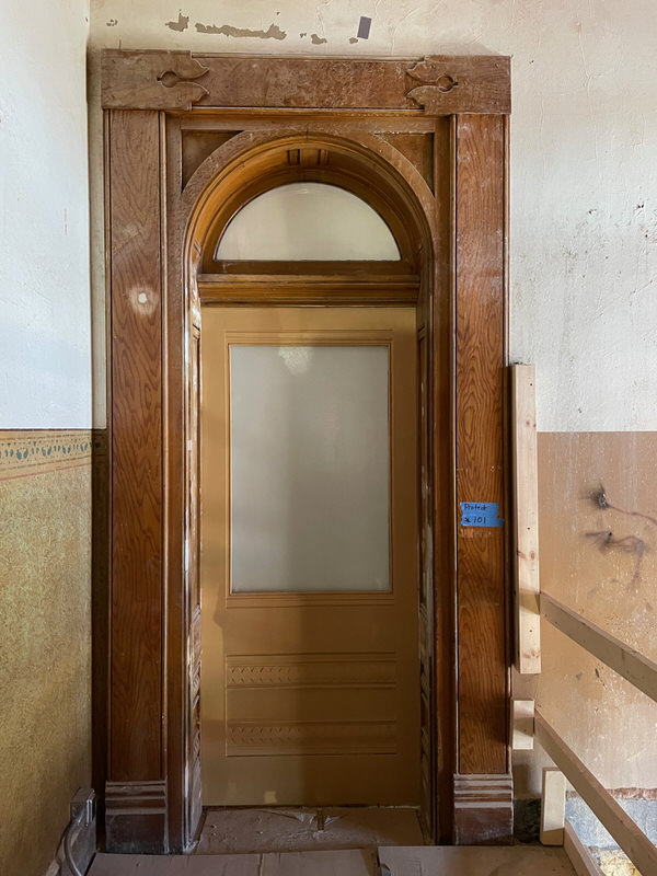 Front view of historic courthouse door restored by Rockwood using durable Ribbon Sapele and custom millwork for code compliance.
