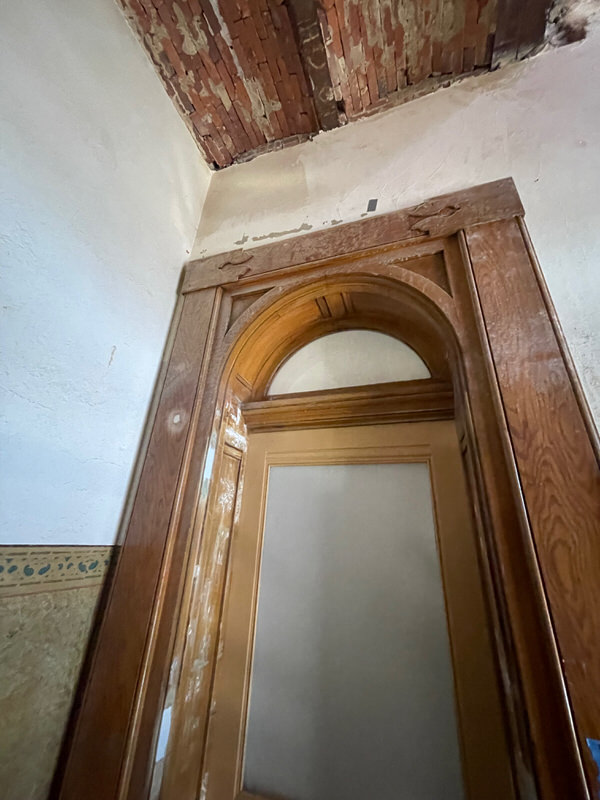 Upward angle showing arched door trim and wood grain detail during courthouse restoration by Rockwood Door and Millwork.