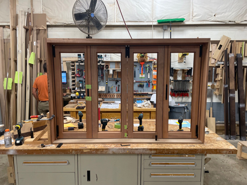 Precision-crafted Sipo pass-through window in fabrication phase, with drill guides and folding hardware setup for Centor system integration.