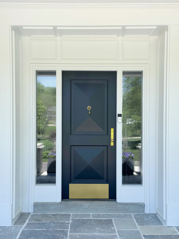 Completed custom entry door with pyramid panels, brass hardware, and bronze threshold crafted by Rockwood for Blue Ladder Studio project.