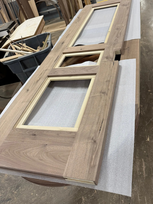 Walnut pocket door frame assembly during fabrication at Rockwood, highlighting structural precision for custom curved interior doors.