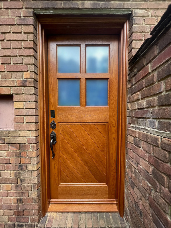 Custom white oak basement door crafted by Rockwood Door and Millwork, faithfully reproducing the original pre-war design in a Cleveland home.