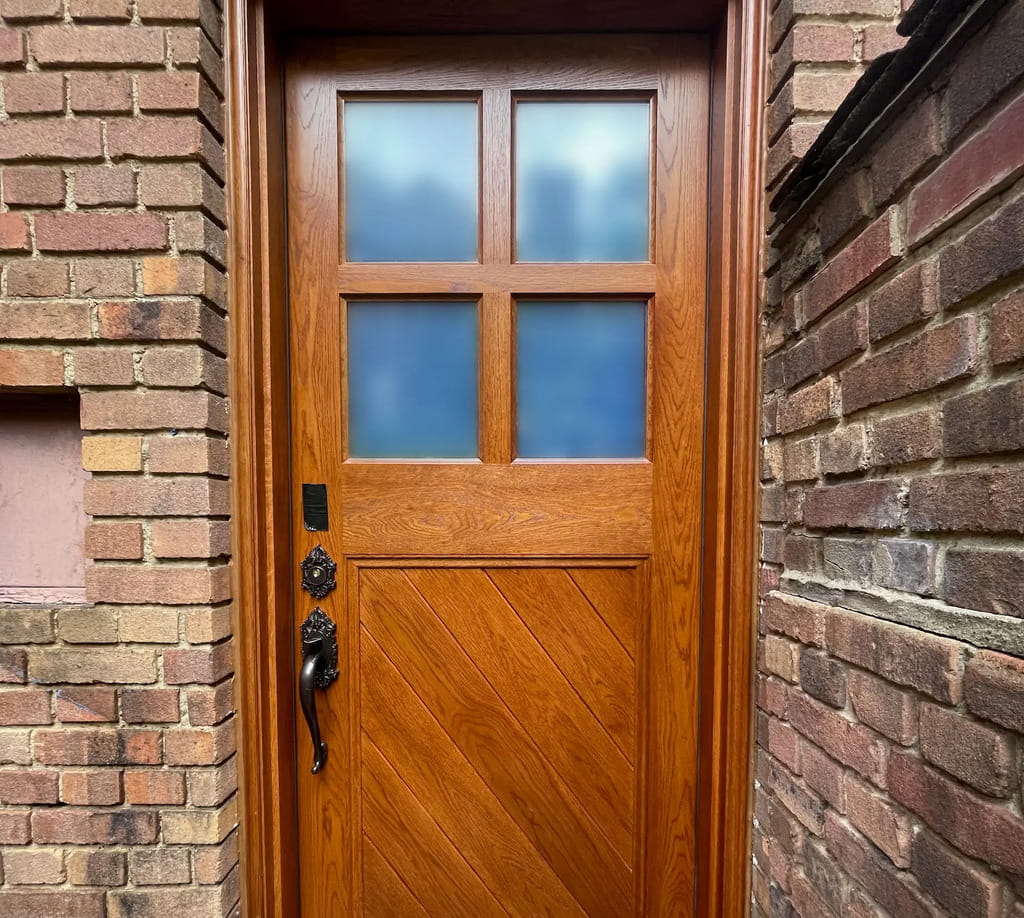 Custom white oak basement door with diagonal plank design crafted by Rockwood Door & Millwork for a restored pre-war Cleveland home.