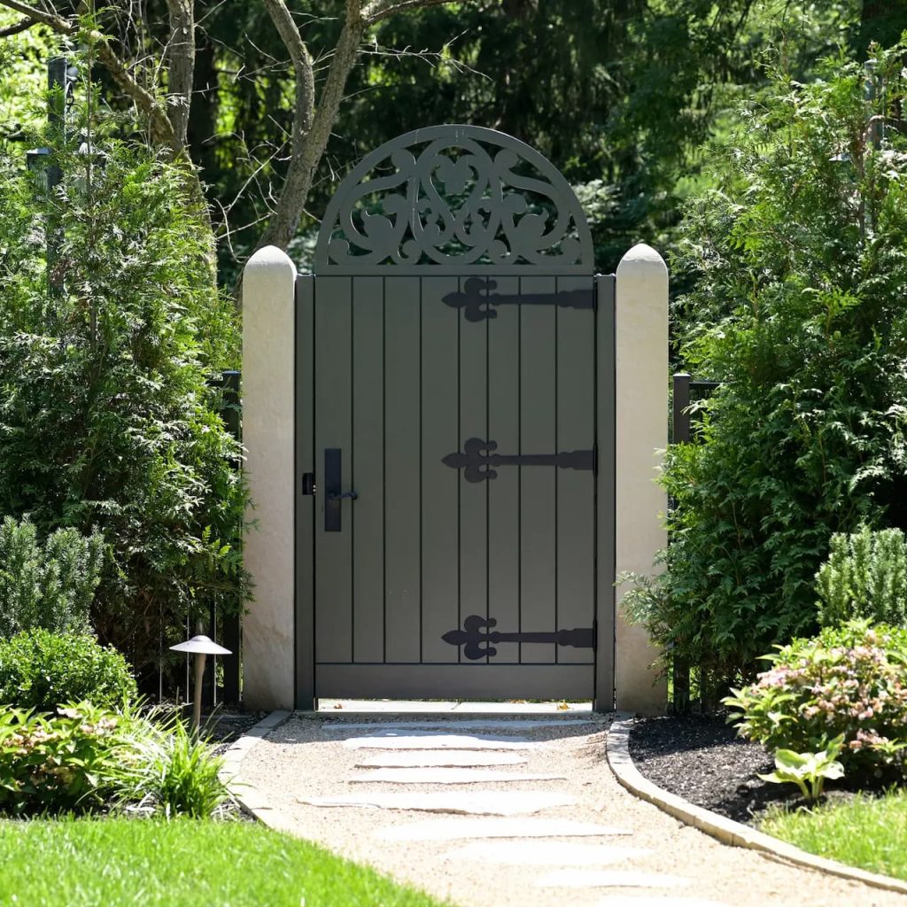 Rockwood used an original gate as the pattern, replicated the half-round top and scrollwork, and rebuilt the gates in mahogany with exterior-grade construction and practical, maintainable finishing.